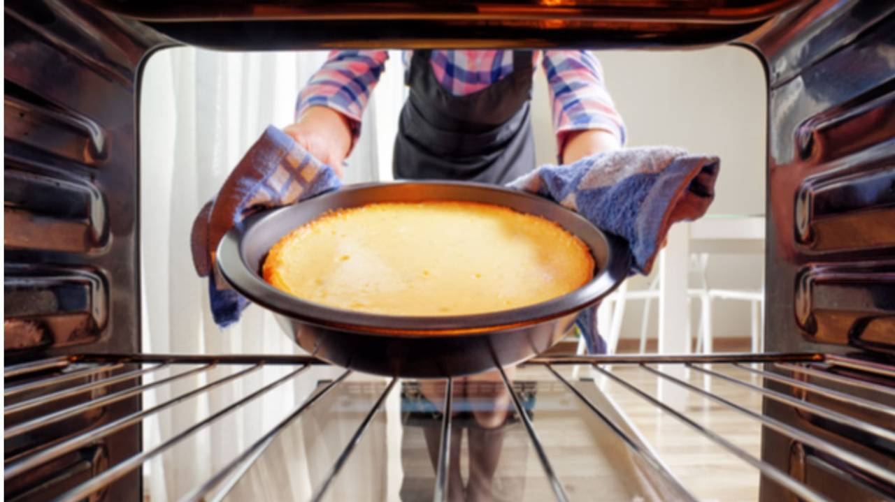 assadeira com bolo sendo colocada dentro do forno