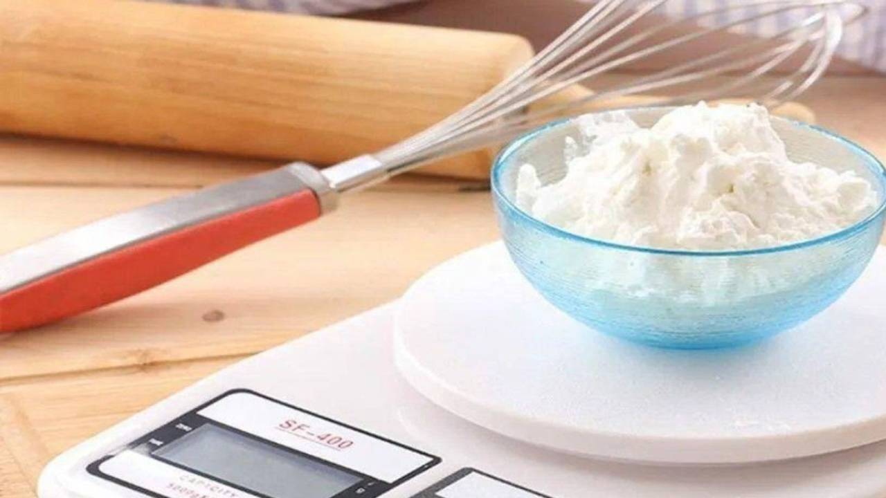 balança de precisão, com um pote de vidro com farinha dentro