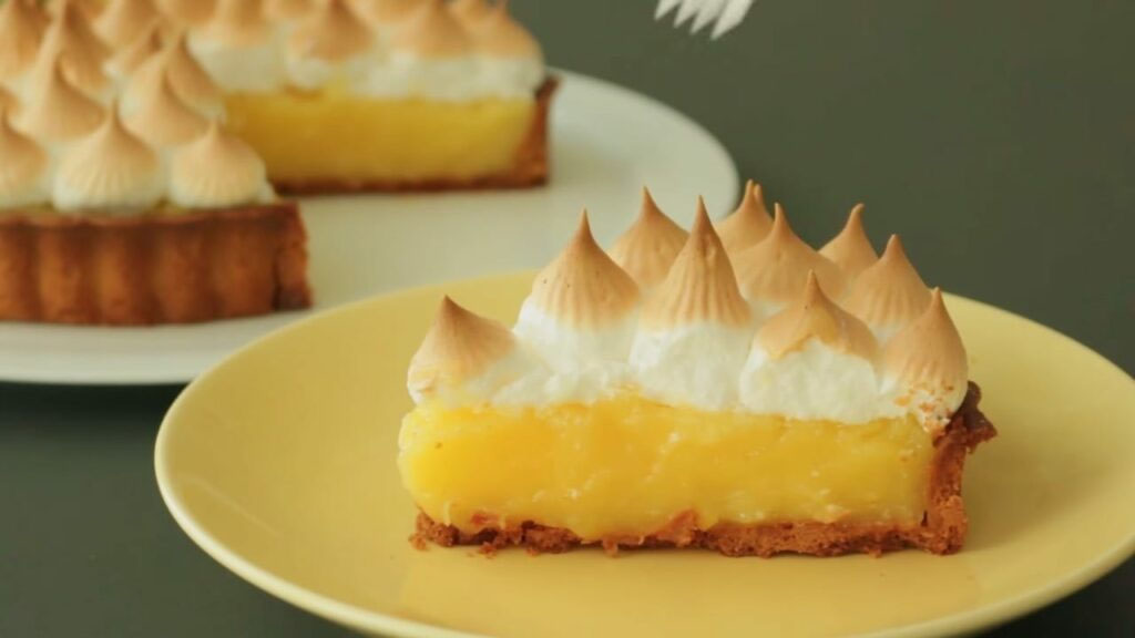 Fatia de torta de limão com merengue em prato amarelo