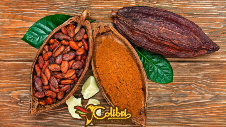 Grãos e pó de cacau com folhas sobre uma mesa de madeira.