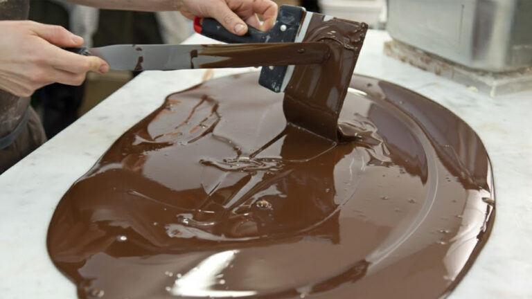 Cobertura de chocolate sendo espalhada na superfície.